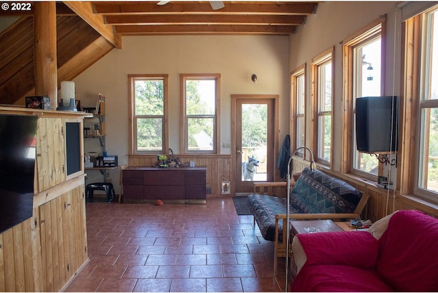 living room featuring dark tile flooring, ceiling fan, and beam ceiling