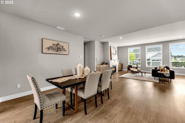 5719 N 87th Ave, Camas, WA 98607 - dining room featuring light wood-style flooring, baseboards, recessed lighting, and a lit fireplace