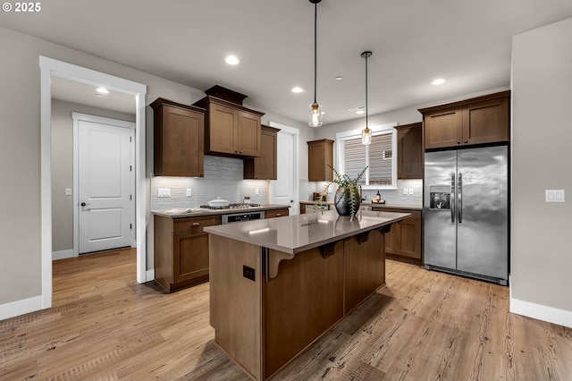 5719 N 87th Ave, Camas, WA 98607 - kitchen with stainless steel appliances, decorative backsplash, light wood-type flooring, a kitchen island, and recessed lighting