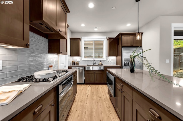 5719 N 87th Ave, Camas, WA 98607 - kitchen with stainless steel appliances, a sink, light wood finished floors, recessed lighting, and tasteful backsplash