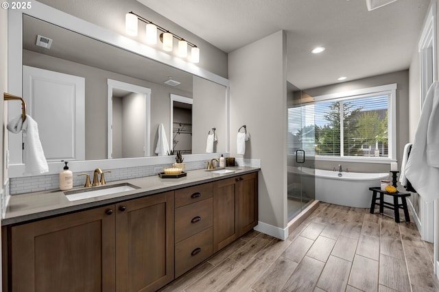 5719 N 87th Ave, Camas, WA 98607 - full bath featuring double vanity, a freestanding bath, a shower stall, decorative backsplash, and wood finished floors