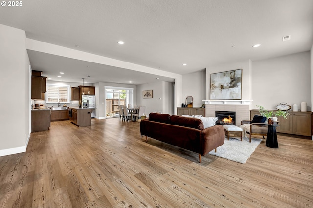 5719 N 87th Ave, Camas, WA 98607 - living room with light wood-style floors, a glass covered fireplace, recessed lighting, and baseboards