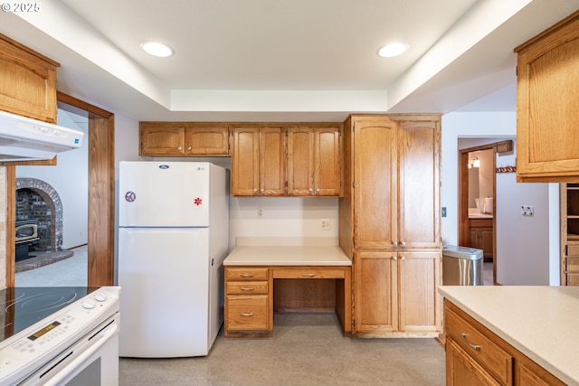 kitchen featuring white appliances, a raised ceiling, and a wood stove