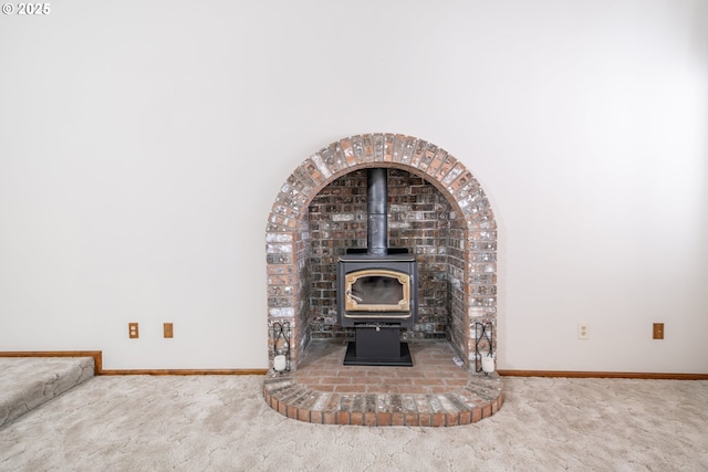 room details featuring a wood stove and carpet floors