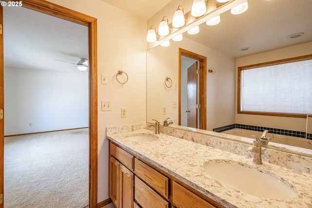 bathroom featuring vanity, a washtub, and ceiling fan