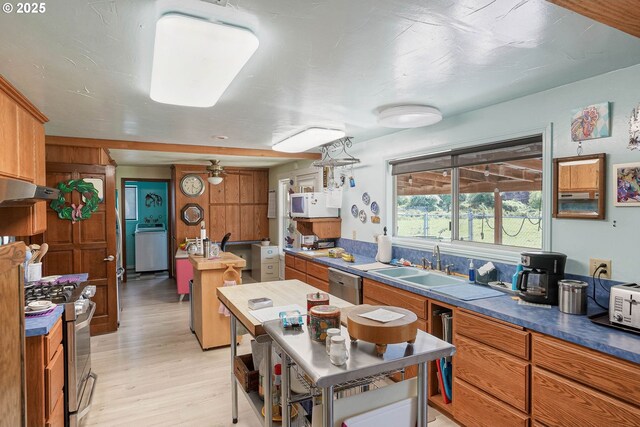 41108/41100 Oupor Dr, Scio, OR 97374 - kitchen with stainless steel appliances, brown cabinets, under cabinet range hood, light wood finished floors, and a sink