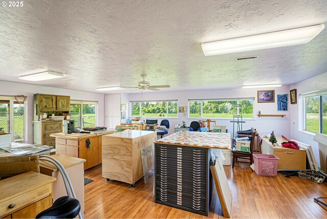 41108/41100 Oupor Dr, Scio, OR 97374 - kitchen featuring a center island, a textured ceiling, light wood finished floors, light countertops, and a ceiling fan