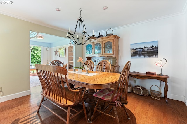 dining area with crown molding, baseboards, and a notable chandelier