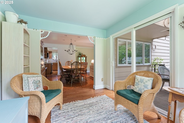 sitting room featuring baseboards, wood finished floors, and a chandelier