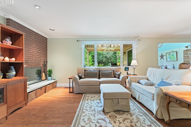 living room with brick wall, baseboards, light wood-style floors, ornamental molding, and recessed lighting