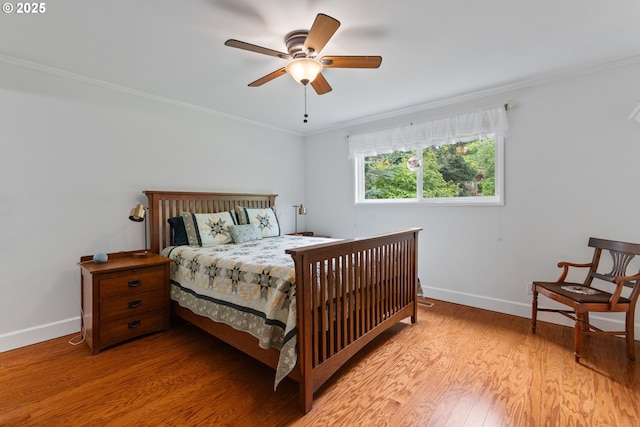 bedroom with baseboards, ornamental molding, a ceiling fan, and wood finished floors