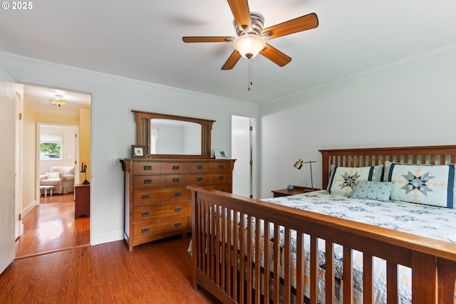 bedroom featuring crown molding, baseboards, ceiling fan, and wood finished floors