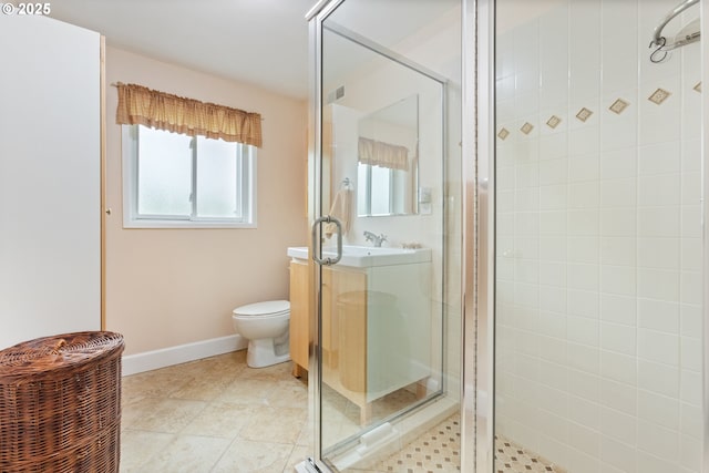 bathroom with baseboards, vanity, toilet, and a shower stall