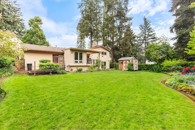 rear view of house with a lawn, an outbuilding, a storage shed, and a vegetable garden