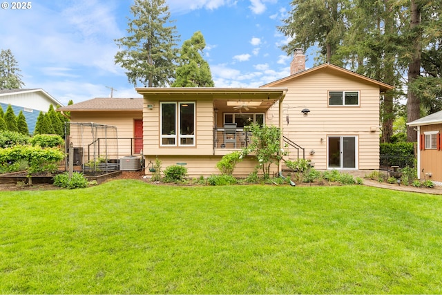 back of property featuring a chimney, central air condition unit, a yard, and a vegetable garden