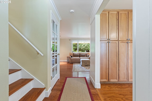 hall with baseboards, stairs, and wood finished floors