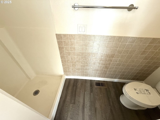 bathroom with tile walls, wood-type flooring, and toilet