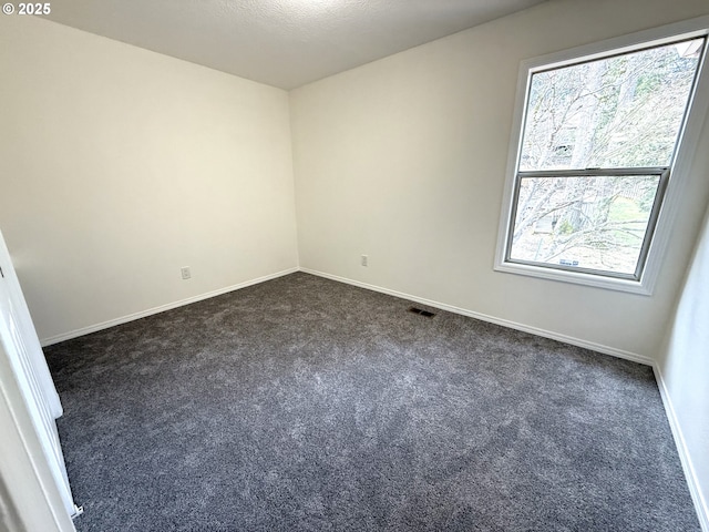 carpeted empty room with a textured ceiling