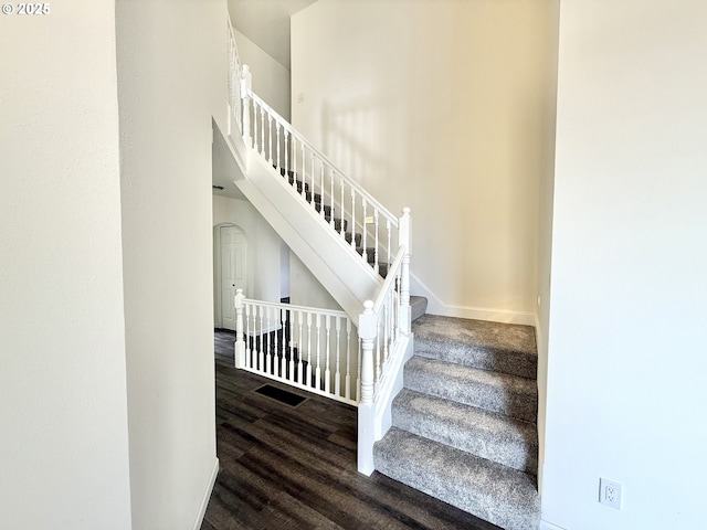 stairway featuring hardwood / wood-style flooring and a high ceiling