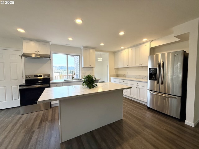 kitchen with appliances with stainless steel finishes, dark hardwood / wood-style floors, a center island, and white cabinets