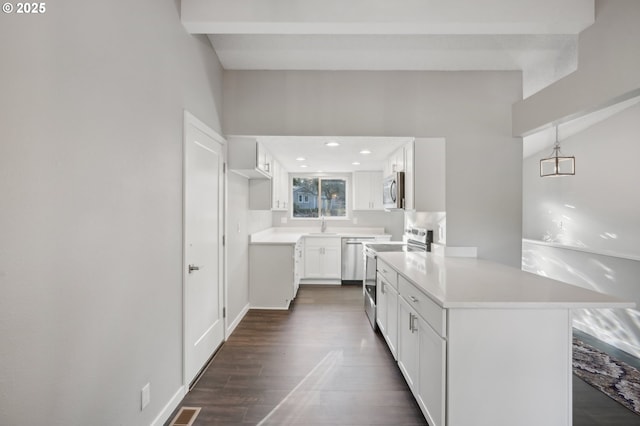 kitchen featuring decorative light fixtures, appliances with stainless steel finishes, dark hardwood / wood-style flooring, kitchen peninsula, and white cabinets