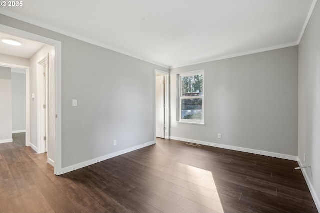 spare room featuring crown molding and dark wood-type flooring