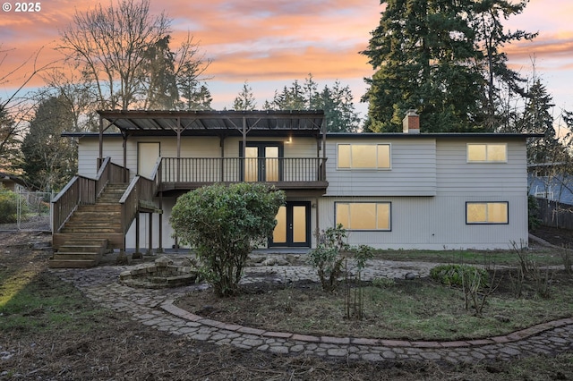 back house at dusk featuring a wooden deck