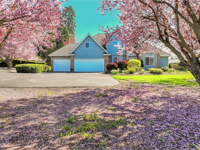 view of front of house featuring brick siding, a garage, and driveway
