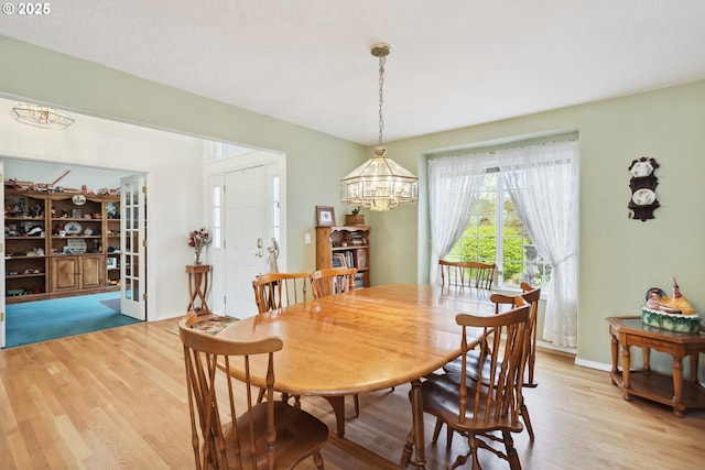 dining space with an inviting chandelier and light wood-style floors