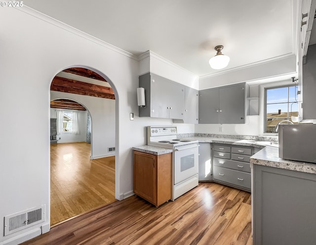 kitchen featuring white electric range oven, visible vents, gray cabinets, and arched walkways