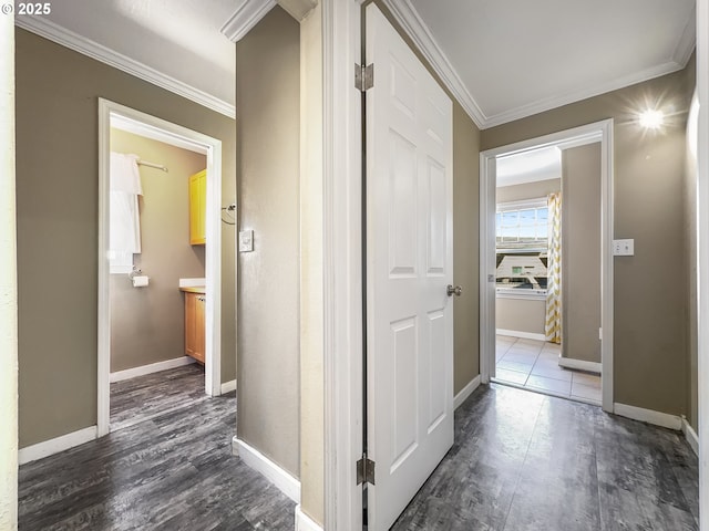 hallway featuring ornamental molding, dark wood-style flooring, and baseboards