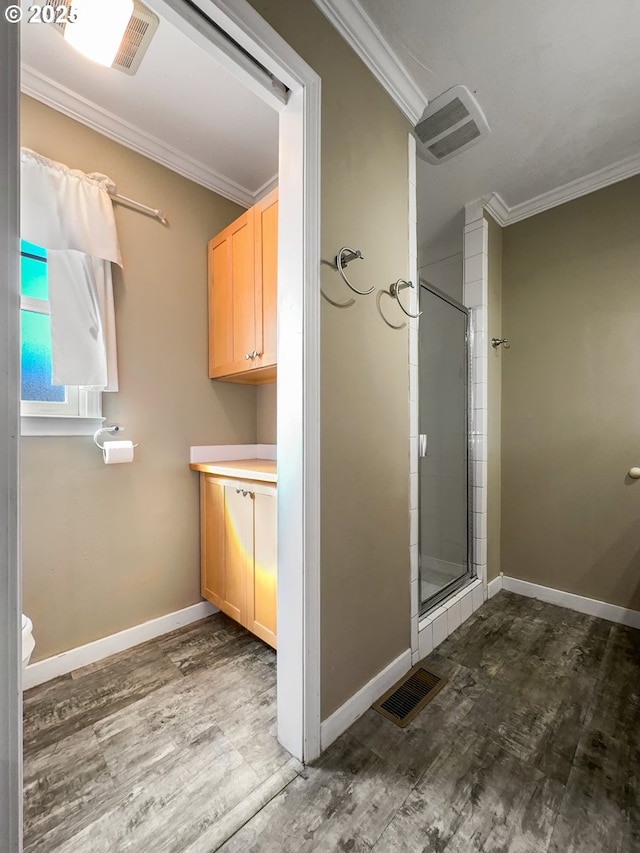 bathroom with ornamental molding, a stall shower, and visible vents