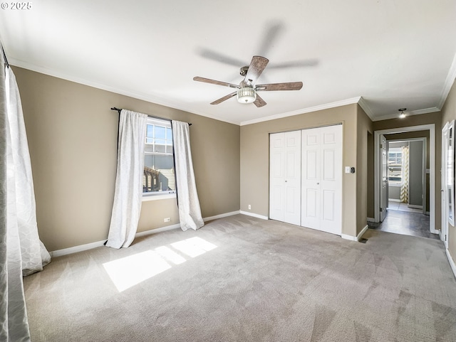 unfurnished bedroom featuring a closet, ornamental molding, baseboards, and carpet floors