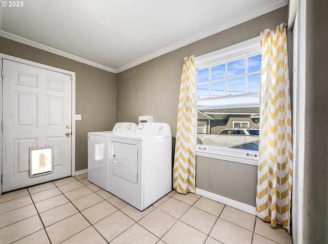 clothes washing area featuring light tile patterned floors, baseboards, crown molding, and washing machine and clothes dryer