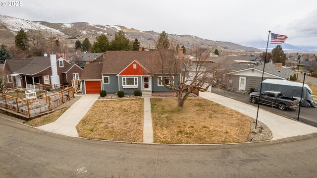 view of front of house with a residential view, a mountain view, and driveway