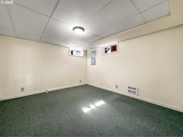 basement with carpet floors, a paneled ceiling, and baseboards