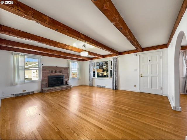 unfurnished living room featuring visible vents, a fireplace, and light wood finished floors