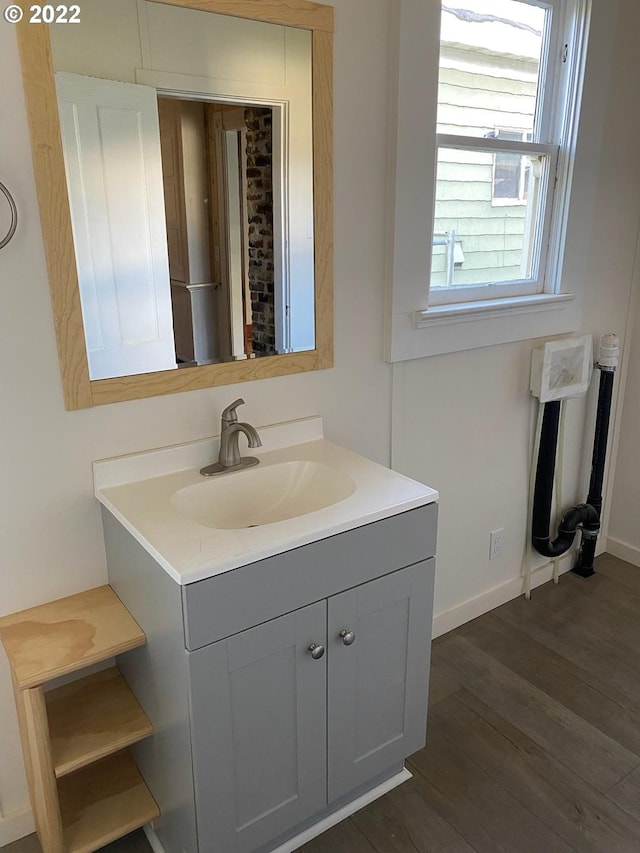 bathroom with vanity, baseboards, and wood finished floors