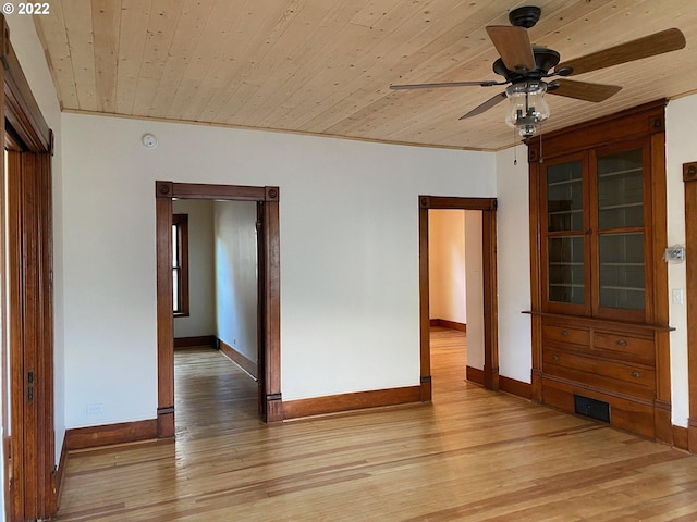 unfurnished room with a ceiling fan, wooden ceiling, baseboards, and light wood finished floors