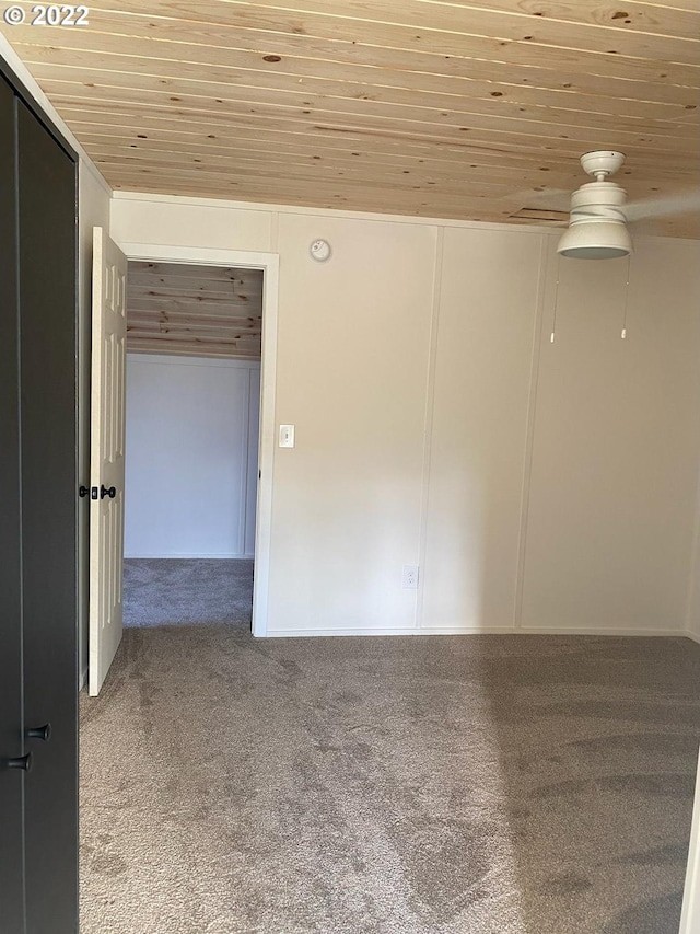 carpeted spare room with wooden ceiling