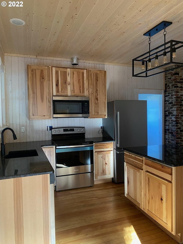 kitchen featuring wooden ceiling, stainless steel appliances, dark stone countertops, and light wood finished floors