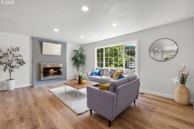 18478 Rose Ct, West Linn, OR 97068 - living area featuring a textured ceiling, recessed lighting, a brick fireplace, and wood finished floors