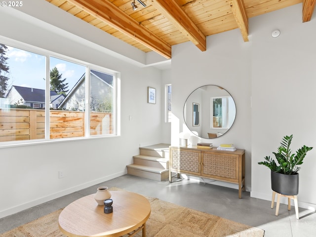 interior space with wooden ceiling, concrete floors, and beam ceiling