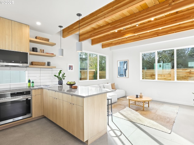 kitchen with pendant lighting, beam ceiling, kitchen peninsula, light brown cabinetry, and oven