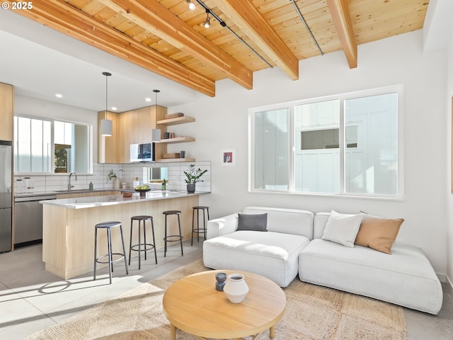 living room with beam ceiling, sink, wood ceiling, and rail lighting