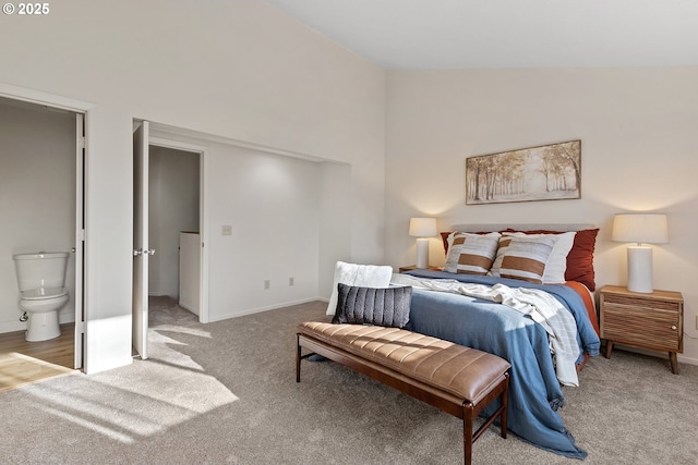 carpeted bedroom with vaulted ceiling and connected bathroom