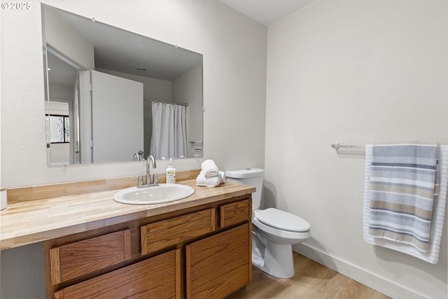 bathroom with vanity, toilet, and hardwood / wood-style floors