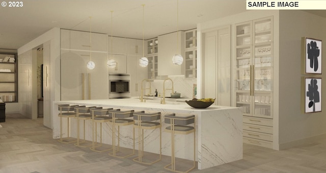 kitchen featuring pendant lighting, oven, a breakfast bar, white cabinets, and light parquet flooring