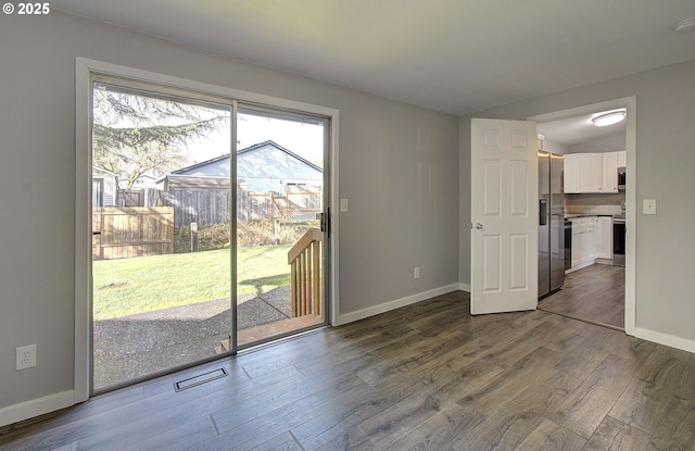 unfurnished room with dark wood-type flooring