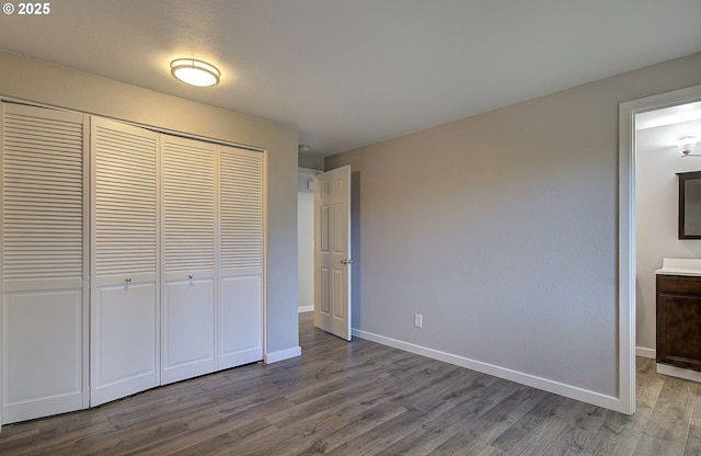 unfurnished bedroom with wood-type flooring and a closet